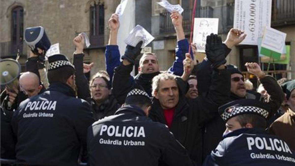 Trabajadores del TMB protestan ante una barrera de los Mossos d'Esquadra.