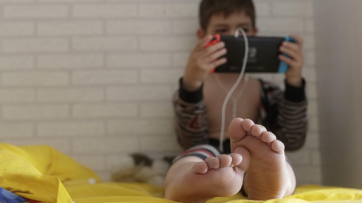 Coronavirus. Un niño de 8 años juega a la videoconsola en su casa durante el confinamiento