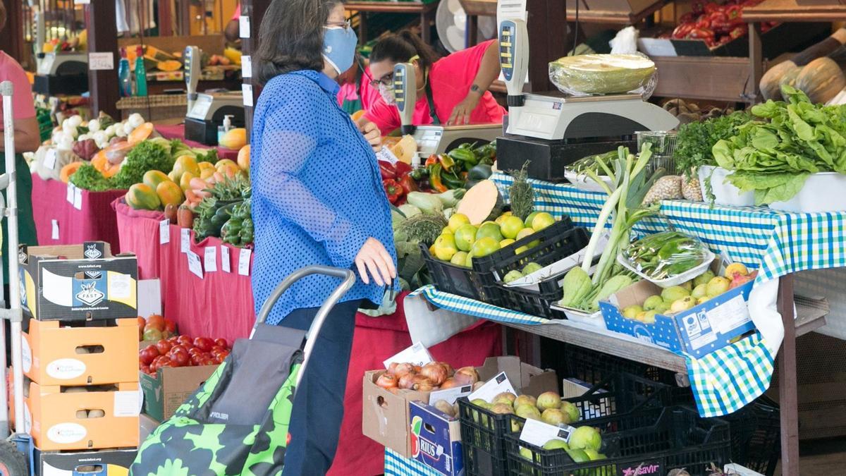 Una mujer comprando en un mercado.