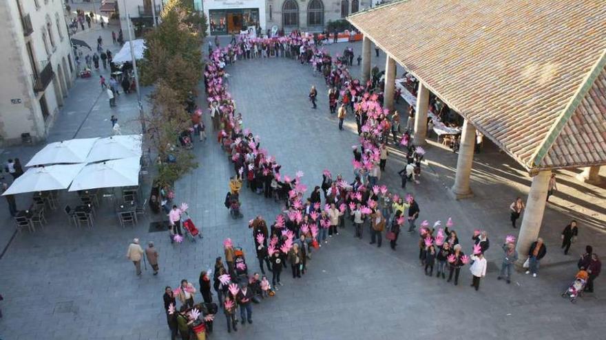 Mujeres forman un lazo humano como símbolo de la lucha contra el cáncer.