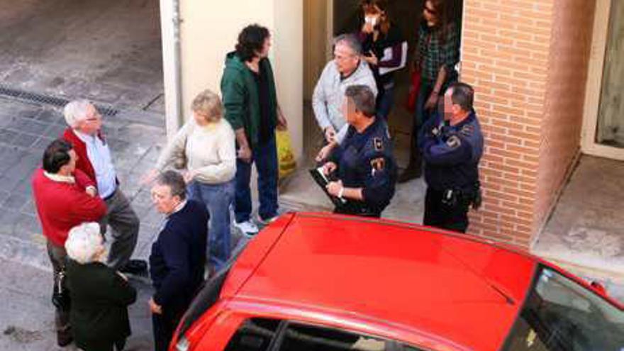 Dos policías dialogan con los vecinos tras el robo.