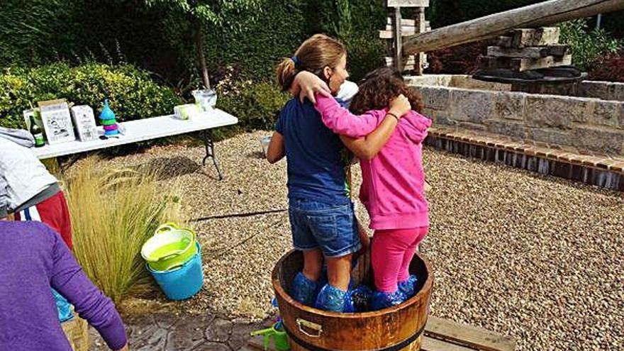 Dos niñas pisando uvas.