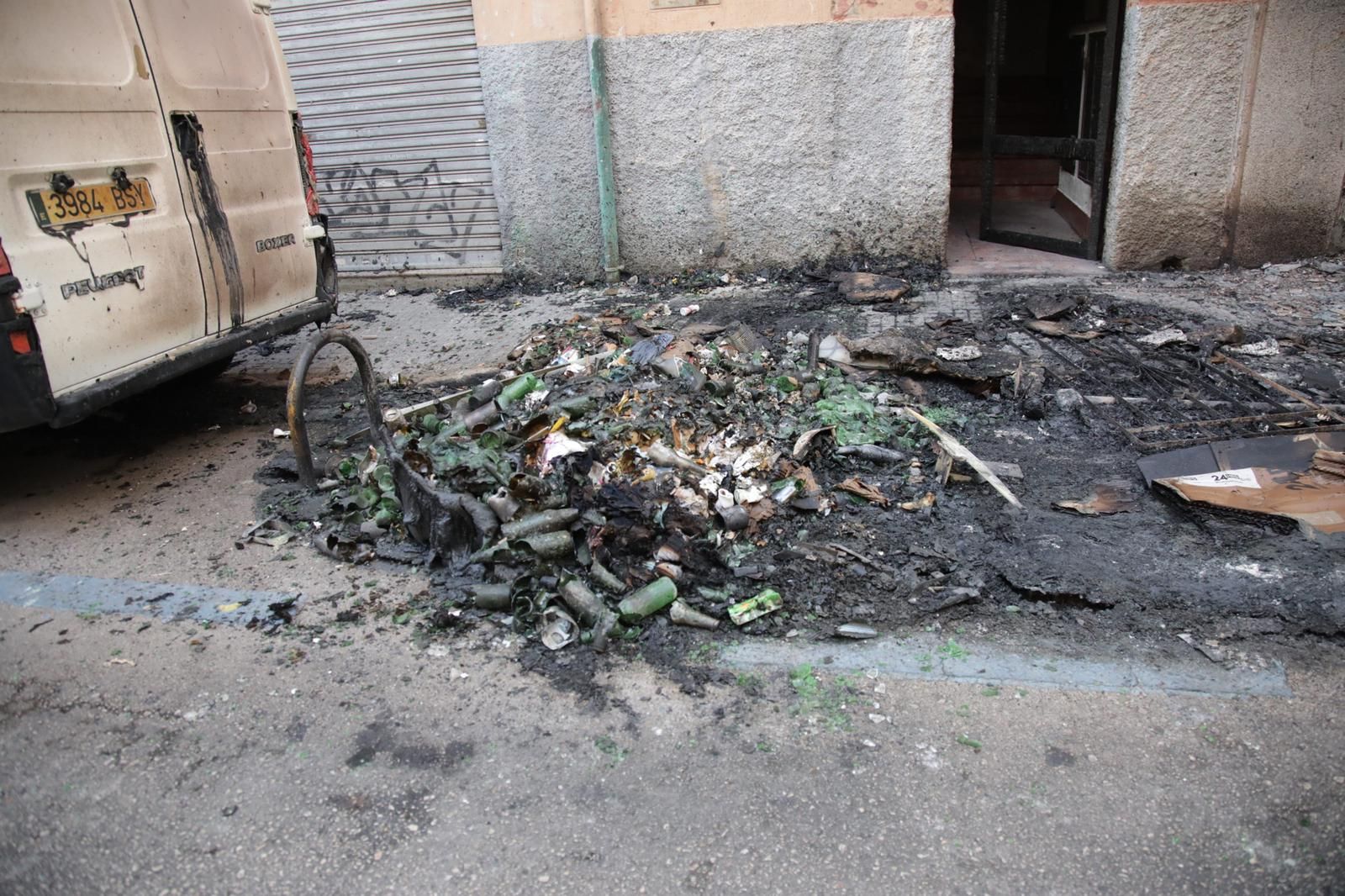 Un incendio destruye contenedores, coches y la fachada de una casa en Palma