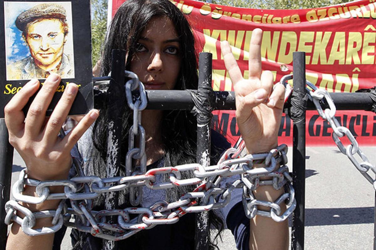 Una manifestant, amb les mans encadenades, fa el signe de la victòria per reclamar llibertat d’expressió a Ankara (Turquia).