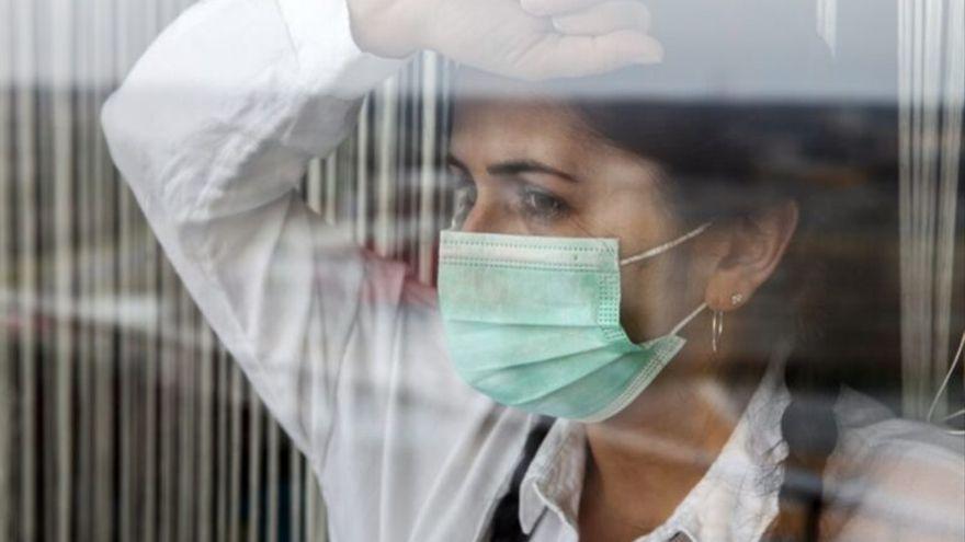 Una mujer con mascarilla reflexiona sobre 2021.