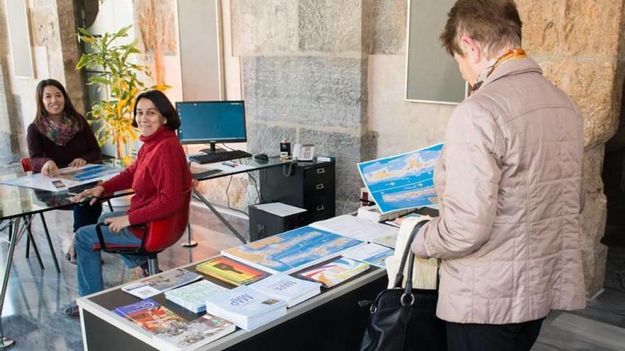 Una mujer observa los folletos turísticos en la oficina.