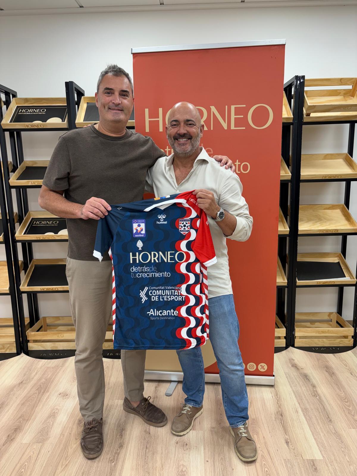 Abraham Rochel (i) y Pepe Sánchez (d) posan con la equipación del Horneo en una de las salas de la panificadora Horneo en Alicante,