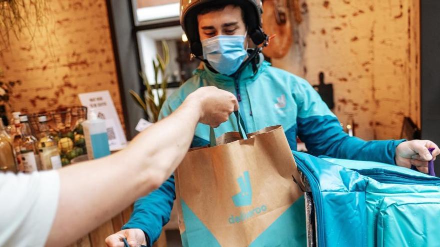 Un repartidor de Deliveroo recoge un pedido en un restaurante.