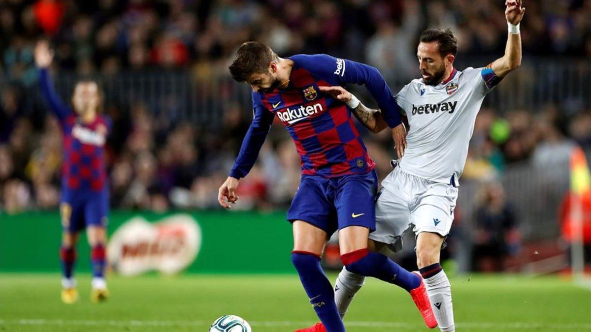 Piqué lucha por un balón con Morales, en el Barça - Levante de LaLiga