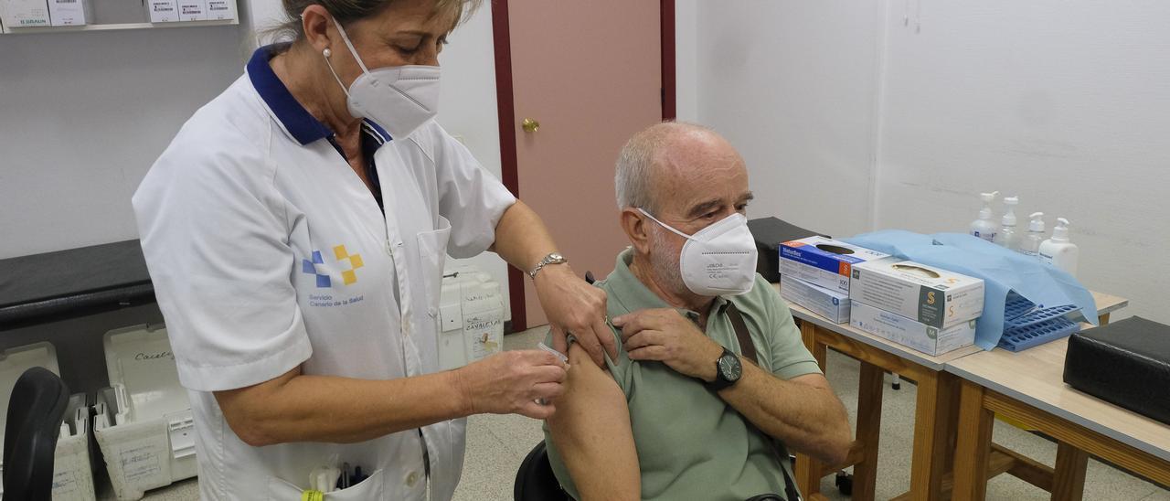 Una enfermera inocula una vacuna contra la gripe a un hombre de más de 60 años.