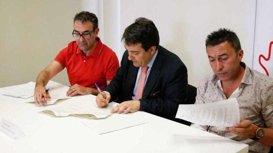 Los responsables de AFA y el director de la oficina principal La Caixa Zamora firman el acuerdo.