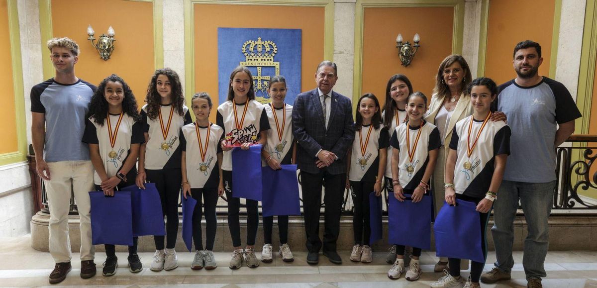 El entrenador Rafael Rodríguez, las jugadoras Alejandra María Mendoza, Ana Marín, Carmen Caballero, Nora Sánchez y Amaya Salceño; el alcalde, Alfredo Canteli; las jugadoras Sara Lebrero, Alicia Olmedo, María Gómez y Elena Vigil; la tercera teniente de alcalde, Conchita Méndez, y el coordinador de las actividades Pablo Luna. | IRMA COLLÍN