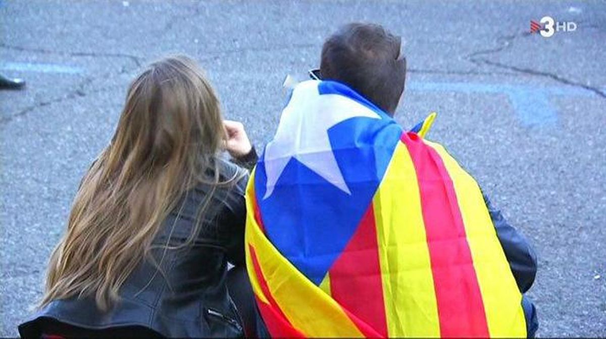 Una pareja espera el inicio del partido de Copa (’TN’, TV-3).