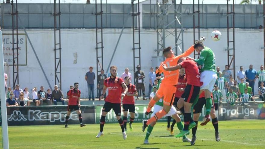 Benji despeja un balón con el puño tras un remate de cabeza de un futbolista del Atlético Sanluqueño.
