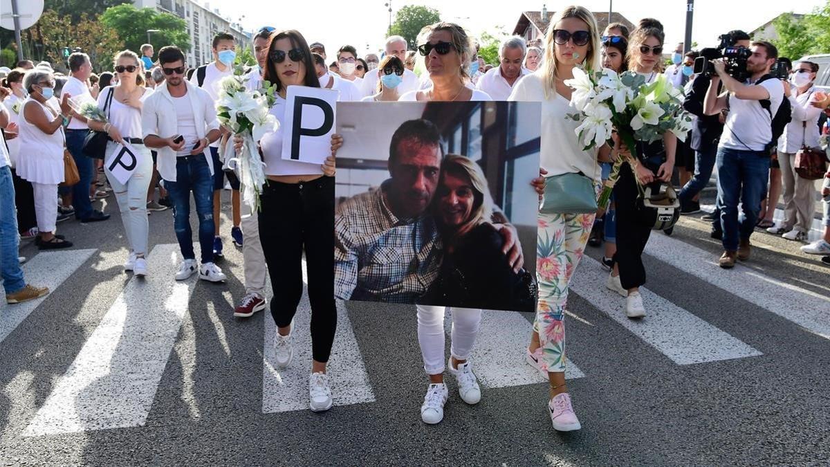 Veronique Monguillot, la mujer del conductor del autobús agredido por negar el viaje sin mascarilla en Bayona (Francia), flanqueda por sus dos hijas, el 8 de julio del 2020, en una marcha silenciosa