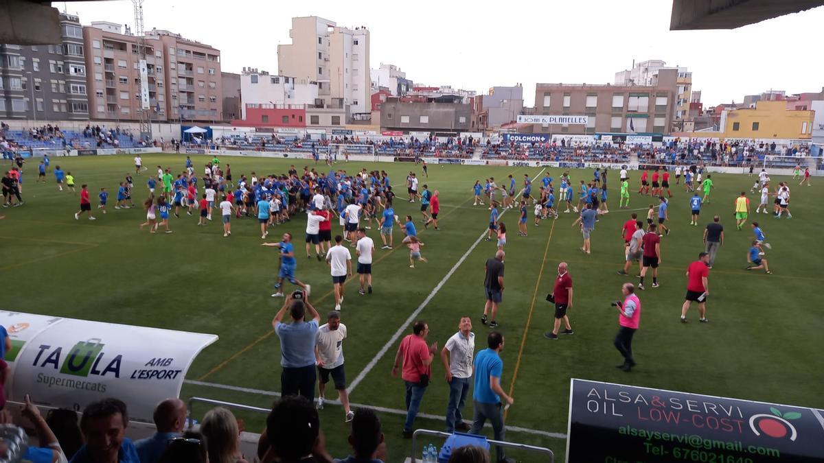 La afición del Burriana celebra el ascenso sobre el césped del estadio.