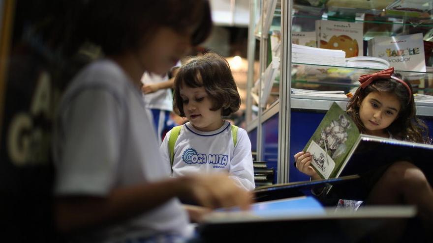 Unas niñas leen varios libros.