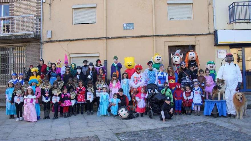 Foto grupal de niños y mayores con disfraces de todo tipo en la villa de Alcañices.