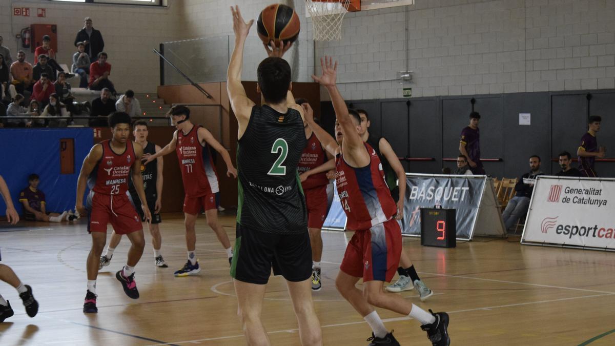 El verd-i-negre Àlex Garrido llança a cistella en una imatge del partit d&#039;aquest matí a Banyoles