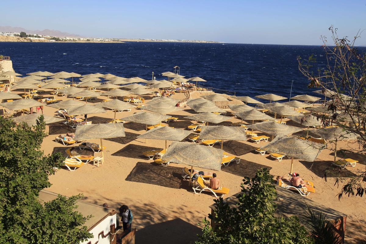 Turistas en la playa del mar rojo en el resort de Sharm el Sheikh en Egipto