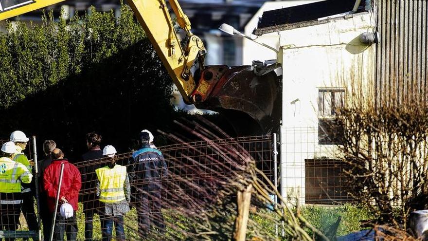 Una excavadora derriba una vivienda en el parque ofimático. 13fotos