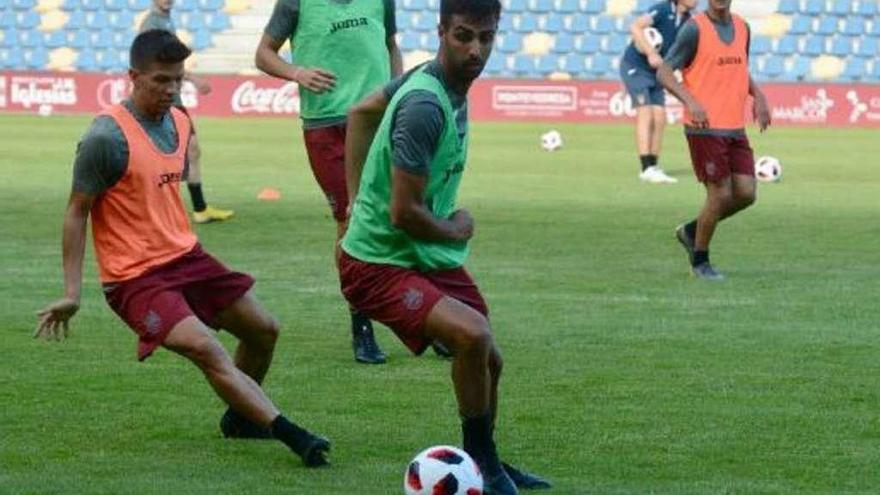 Romay protege el balón ante la presión de Antón durante un entrenamiento. // Rafa Vázquez