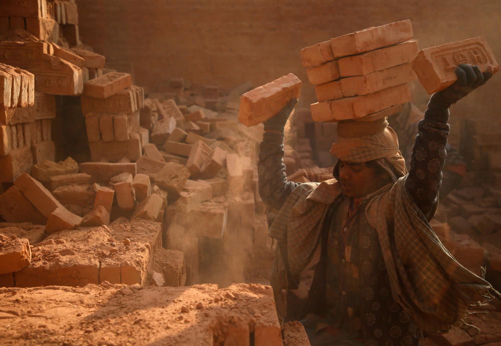 A worker stack bricks on his head at a brick ...