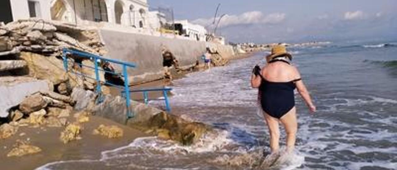 Los bañistas pasan por el tramo más deteriorado de les Deveses.