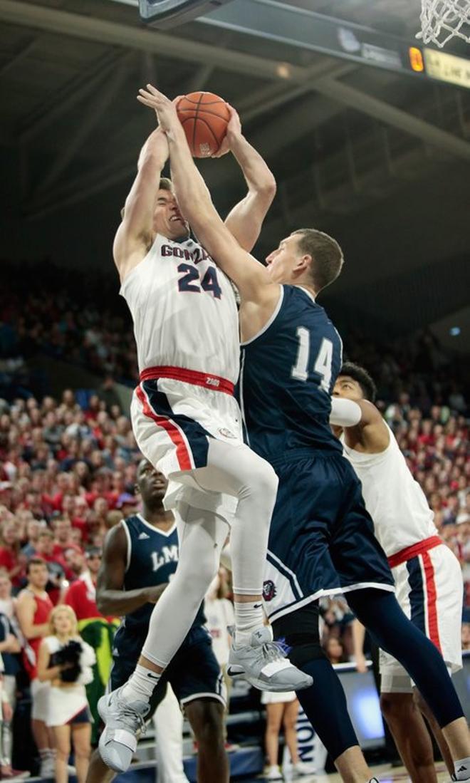 Corey Kispert # 24 de los Bulldogs de Gonzaga va a la canasta y recibe una falta de Mattias Markusson # 14 de los Loyola Marymount Lions en la primera mitad en el McCarthey Athletic Center.