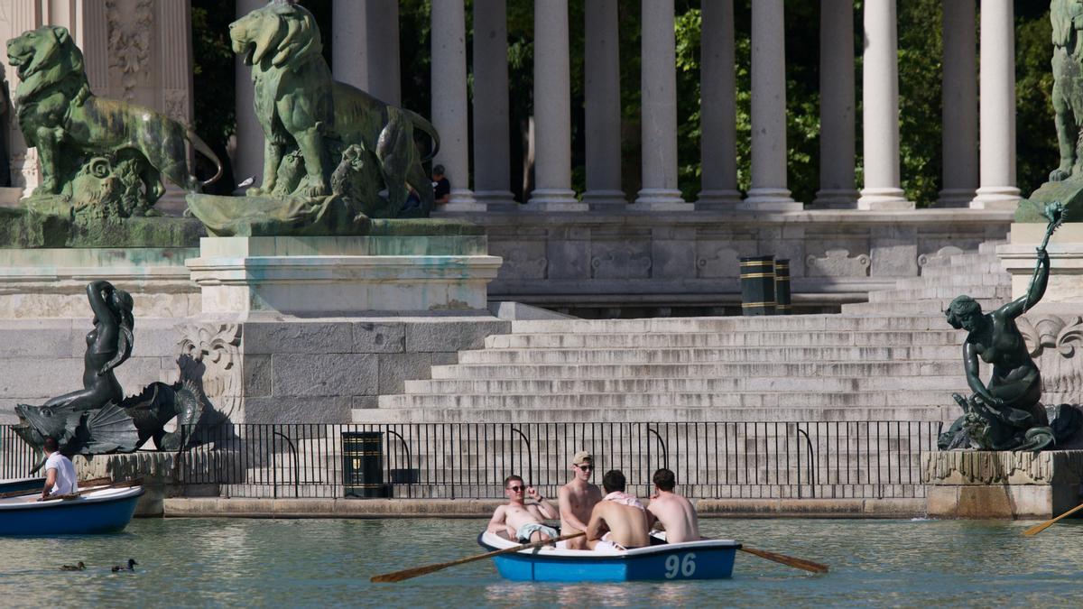 Un grupo de chicos, sin camiseta, en las barcas del Retiro, en Madrid.