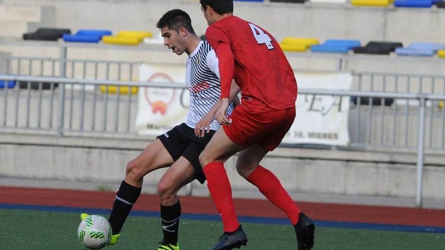 Roni protege el balón ante la oposición de un central del Izarra.