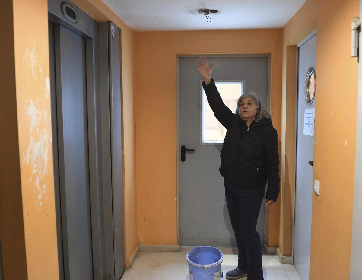 Maite Orduña, portavoz de los vecinos, con las deficiencias del rellano de uno de los bloques.  | |  C. PARDELLAS