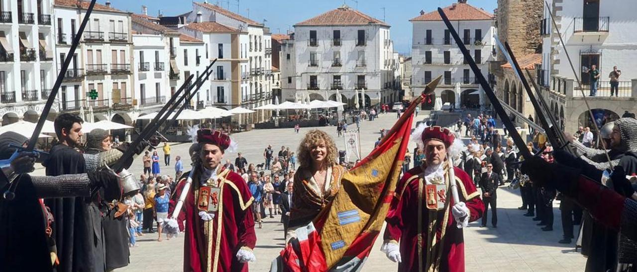 La concejala del PSOE Paula Rodriguez, la más joven de la corporación de Cáceres, acompañada de los maceros camino del ayuntamiento para tremolar el pendón de San Jorge.