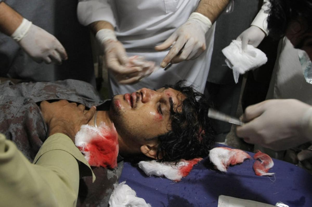 Personal sanitario atiende a un joven herido en Peshawar.