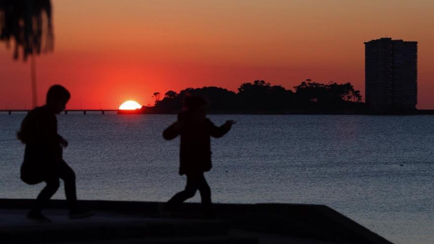 Niños jugando durante una puesta de sol en Vigo. // J. Lores