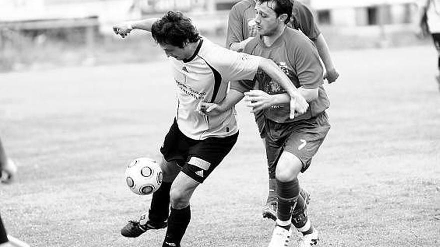 El atacante luarqués Mario protege el cuero ante el marcaje del defensa condalista Trubi.