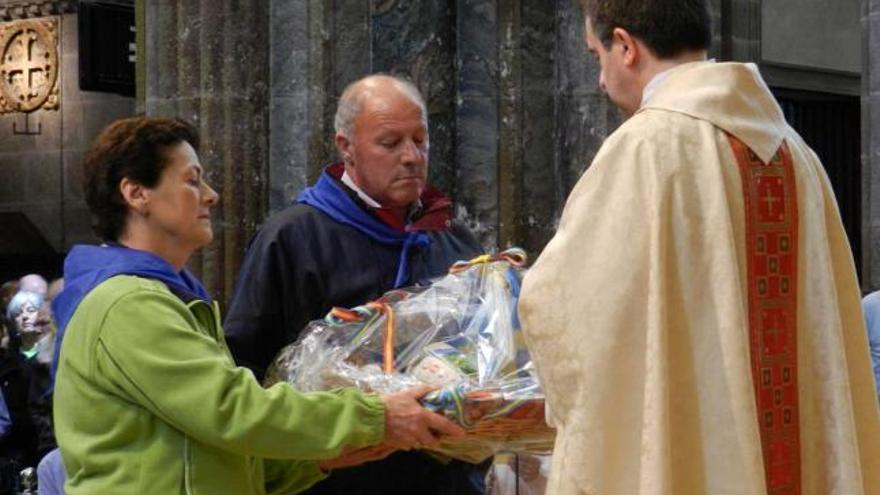 Mari Luz Ordiales y Constantino de la Vega hacen la ofrenda de güevos pintos en la catedral.
