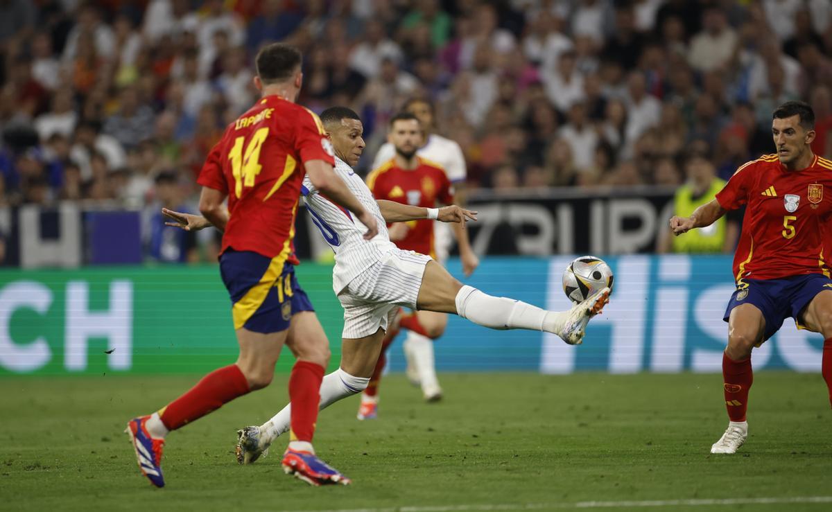 El delantero de la selección francesa Kylian Mbappé trata de controlar un balón ante el español Daniel Vivian, durante el partido de semifinales de la Eurocopa de fútbol que España y Francia