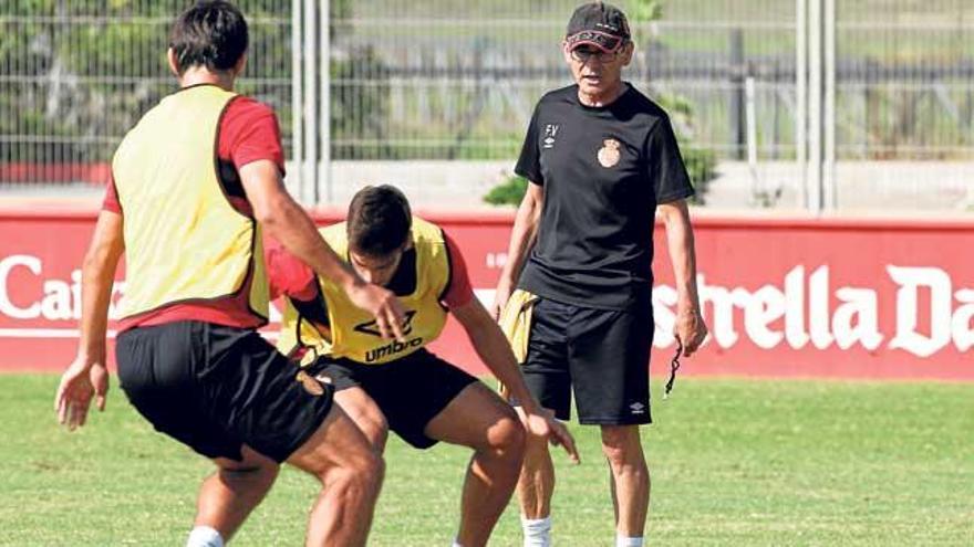 Fernando Vázquez observa de cerca a dos futbolistas durante un entrenamiento en Son Bibiloni.