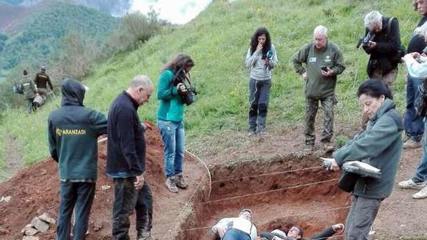 Expertos y familiares, tendidos en la fosa para elaborar imágenes que faciliten la investigación.