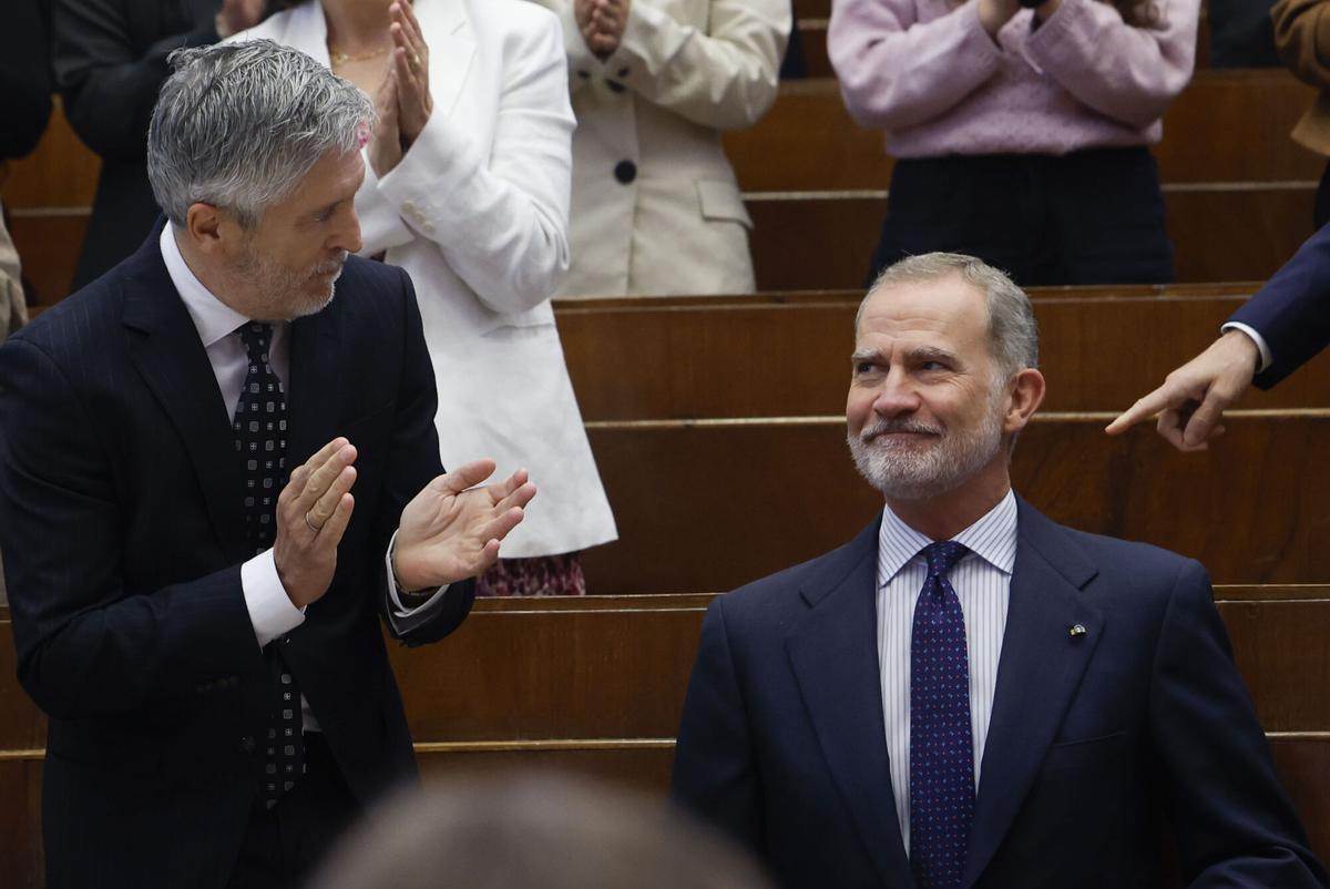 El ministro del Interior, Fernando Grande-Marlaska, aplaude a Felipe VI en el acto celebrado, el jueves, en la Facultad de Derecho de la Universidad Complutense de Madrid.