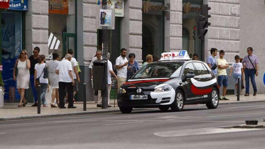 Un coche de autoescuela circula por la ciudad, ayer por la tarde.