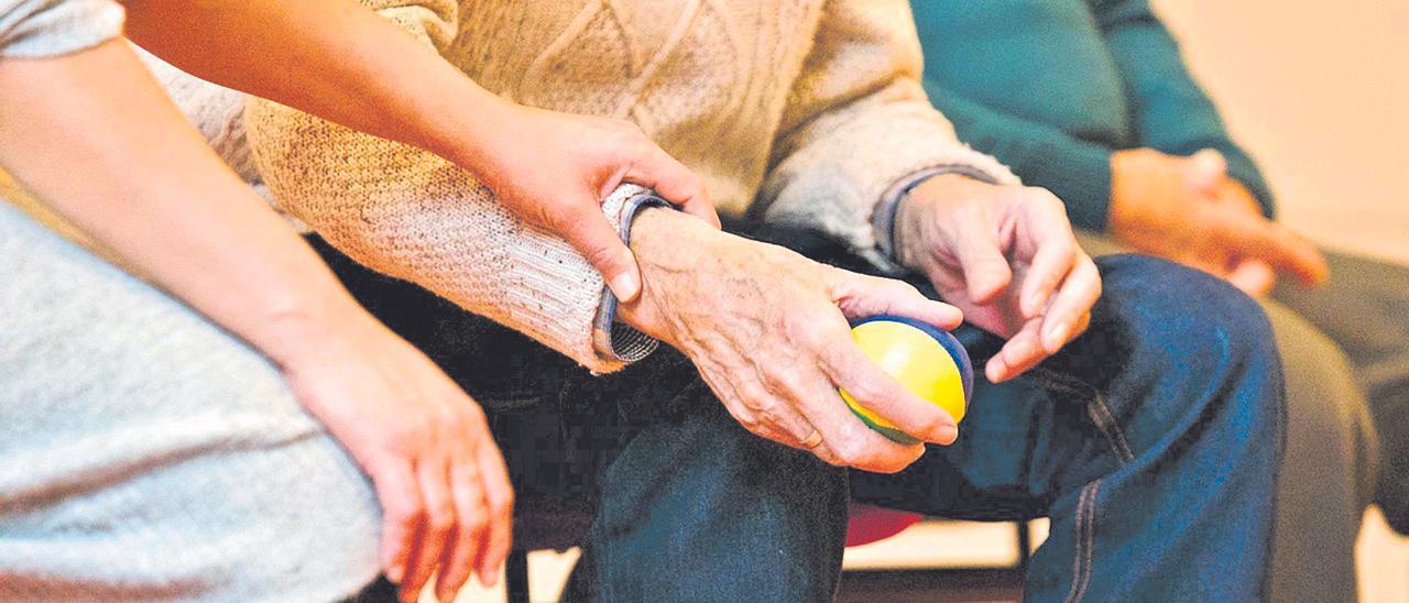 Una persona toma de la mano a un anciano