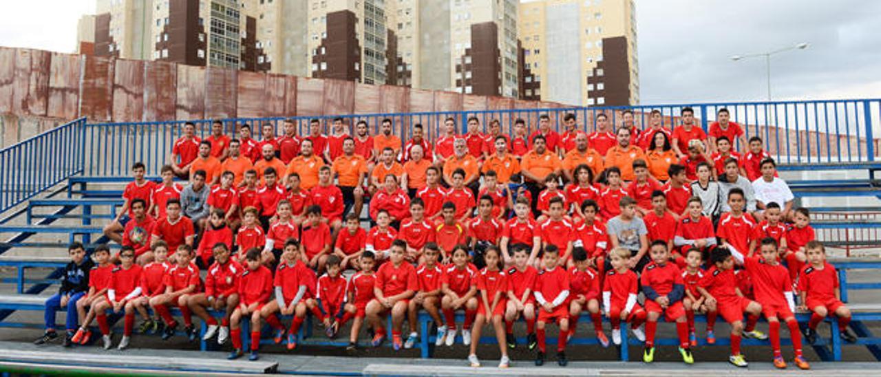 Formación con veinticinco jugadores de categoría juvenil del Vallinamar y tres de sus técnicos, en el campo en el juegan y entrenan.