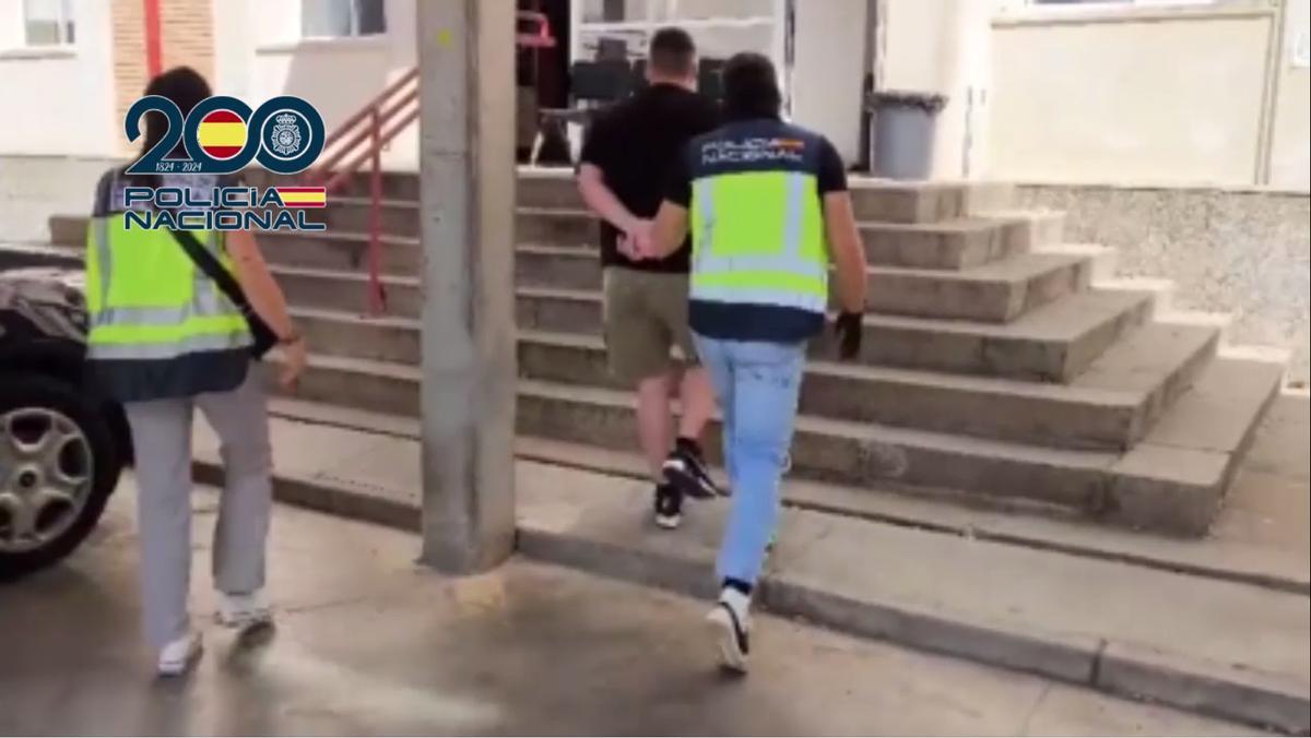 Uno de los arrestados es conducido por los agentes a la comisaría.