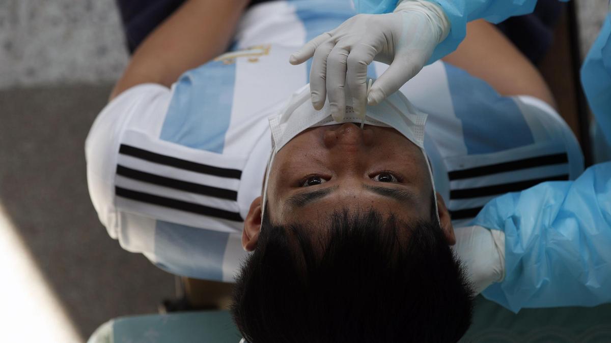 Un sanitario realiza una prueba PCR a un paciente.