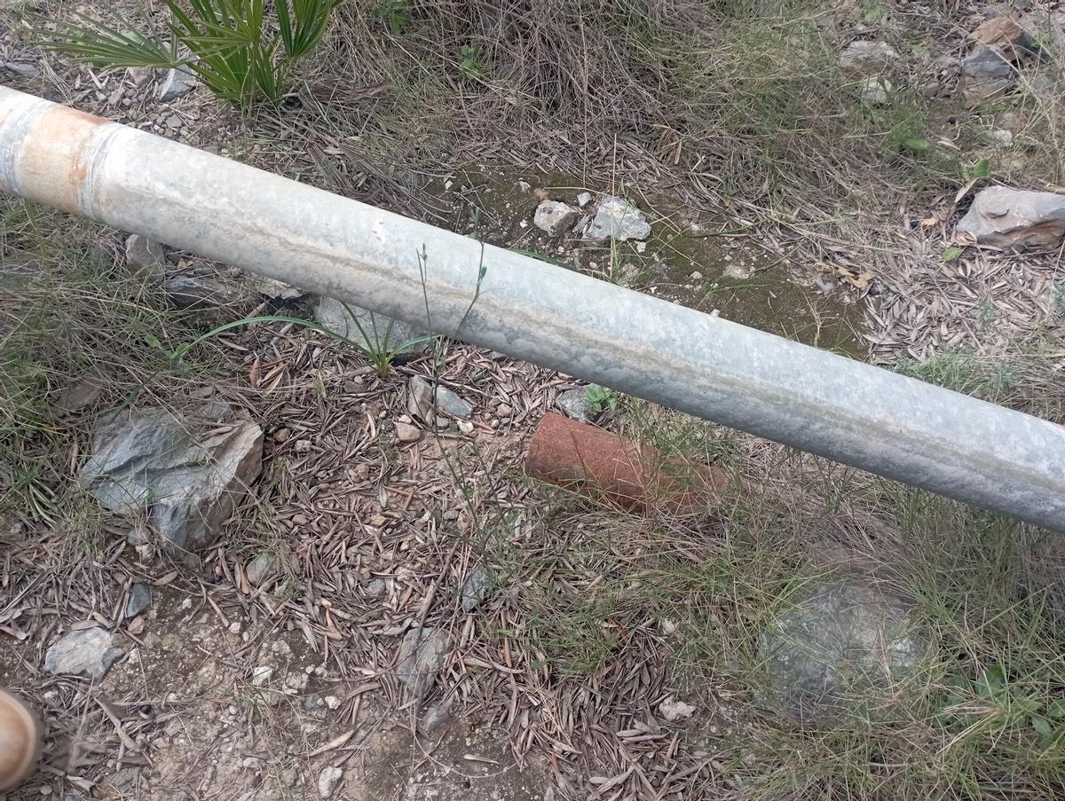 Un tramo de tubería oxidada, distinta a la retirada, asoma bajo la que conduce electricidad hace una semana.