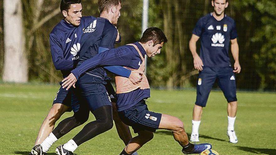 Folch y Carlos Hernández presionan a David González en el entrenamiento de ayer en El Requexón.