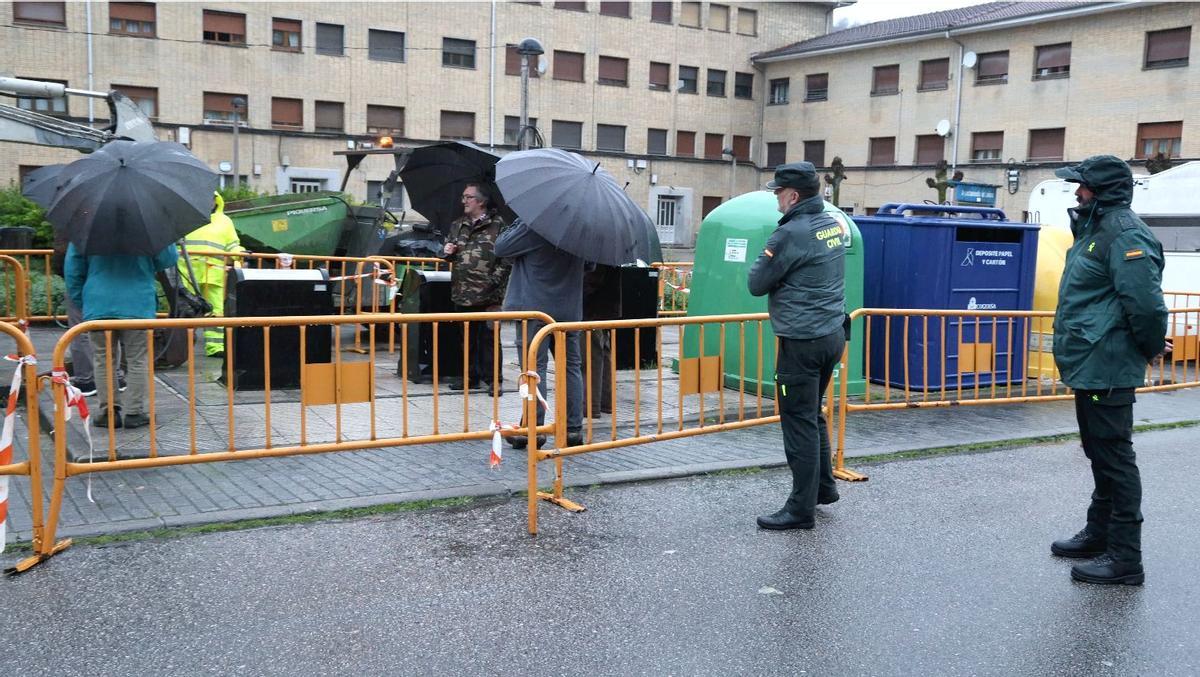 Agentes de la Guardia Civil vigilan a los vecinos de Barredos que intentan evitar la retirada de los contenedores subterráneos