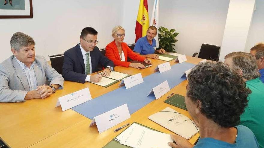El conselleiro de Medio Rural y Corina Porro firman el acuerdo con la mancomunidad de montes. // FdV